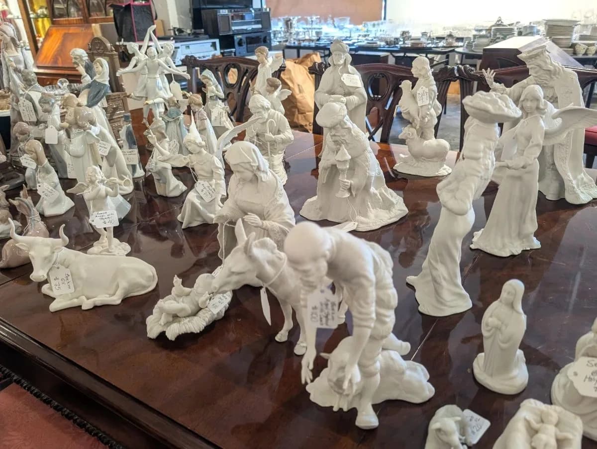 White porcelain figurines arranged on a polished mahogany dining table